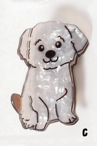 White dog-shaped claw clip with black outline on a white background