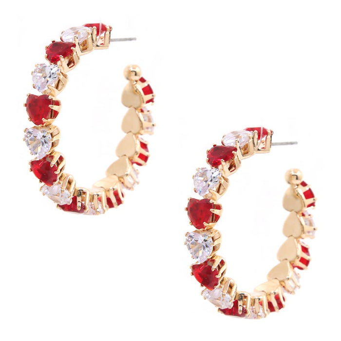 A pair of gold hoop earrings decorated with alternating red heart-shaped crystals and clear round-cut crystals, set against a plain white background.