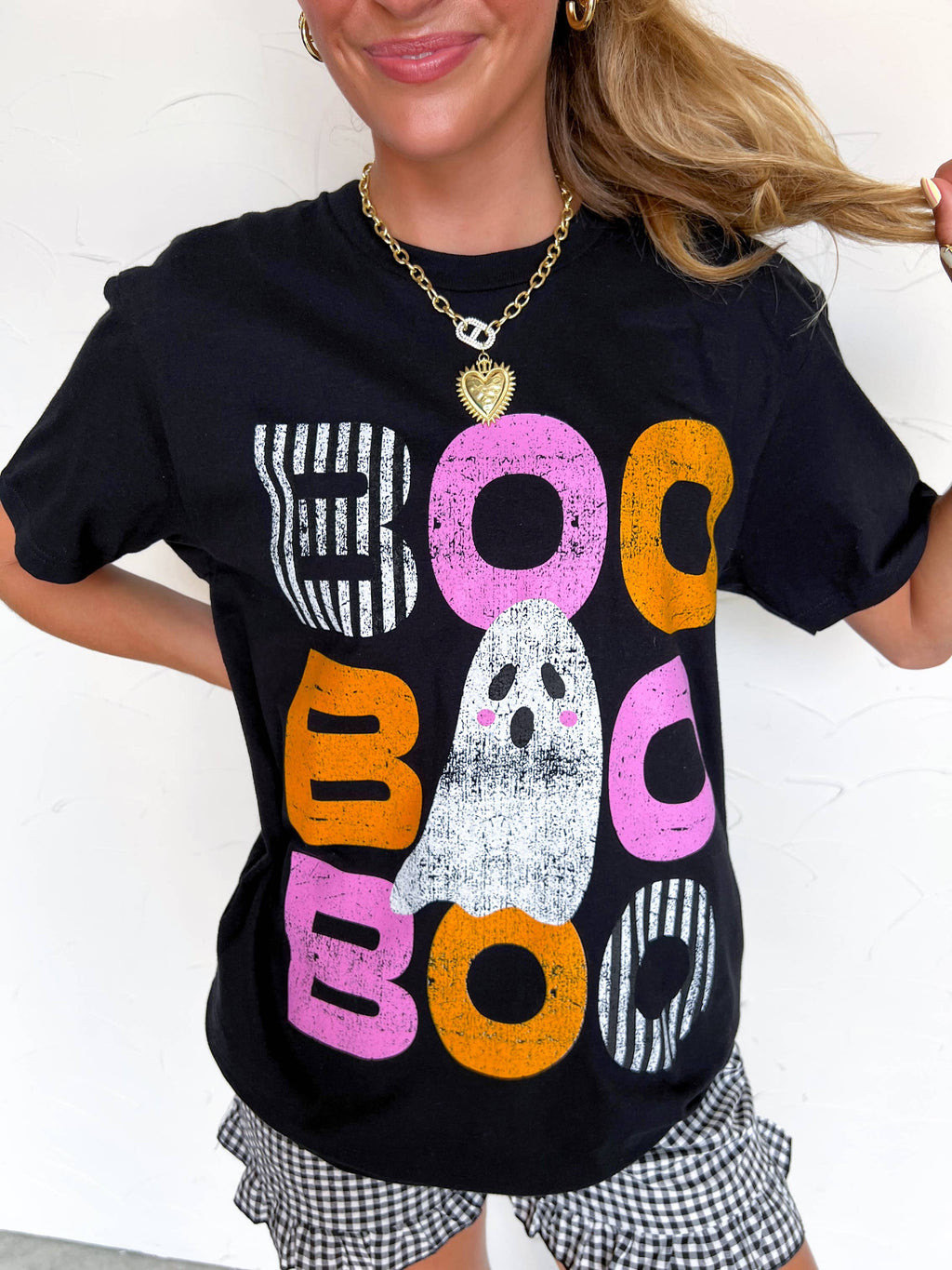 Person wearing a black t-shirt with colorful 'BOO' text and ghost graphic.