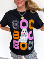 Person wearing a black t-shirt with colorful 'BOO' text and ghost graphic.