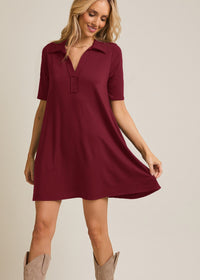 Woman wearing a burgundy dress with short sleeves on a beige background