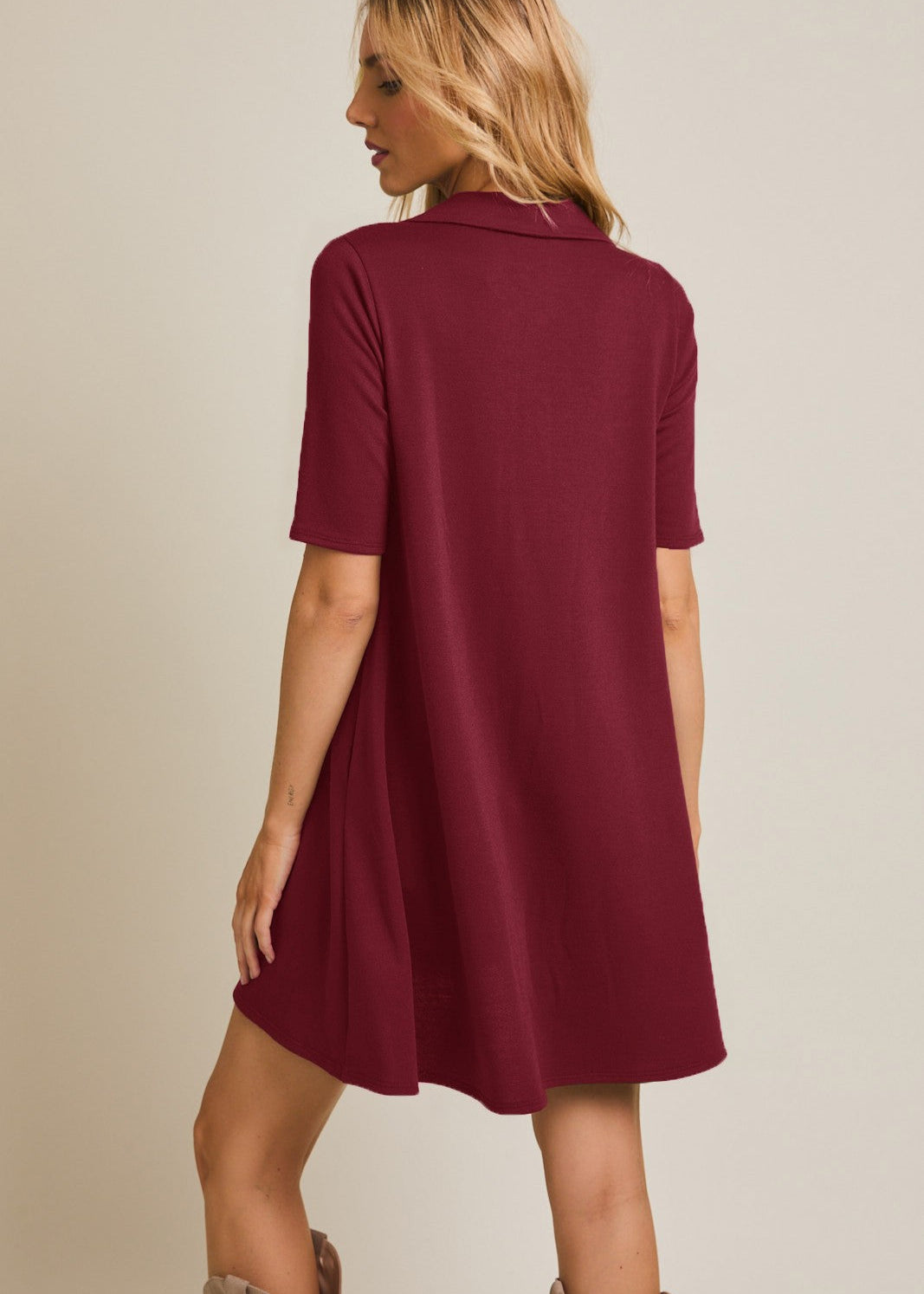 Woman wearing a burgundy dress with a plain background