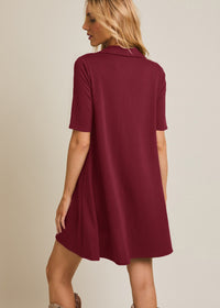 Woman wearing a burgundy dress with a plain background