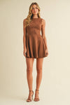 Woman wearing a brown dress against a beige background