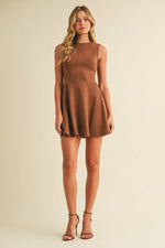 Woman wearing a brown dress against a beige background