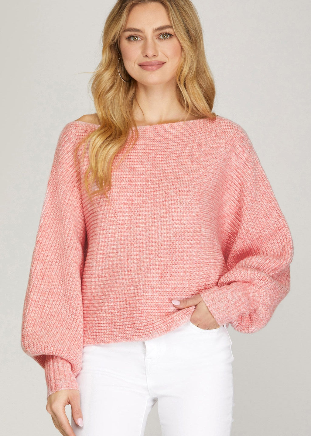 Woman wearing a pink sweater against a plain background