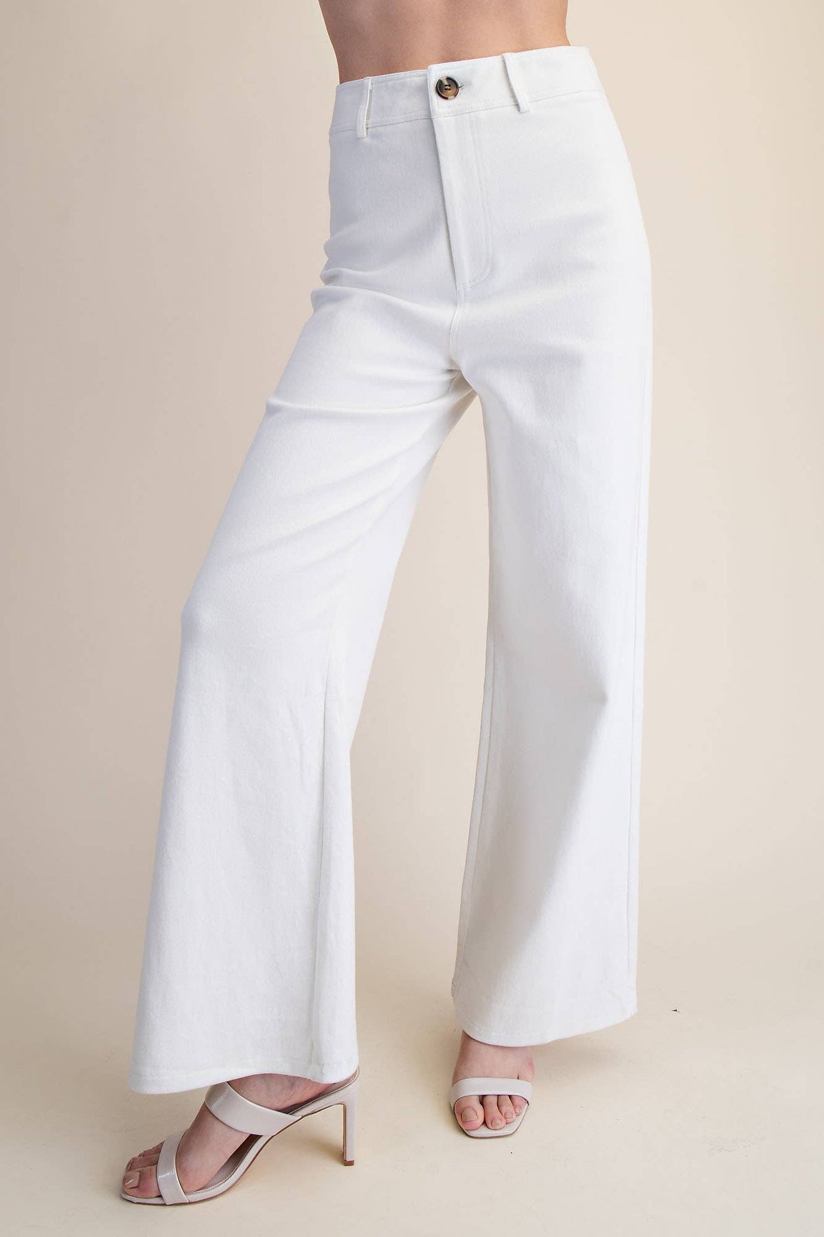 White wide-leg pants worn by a person on a beige background