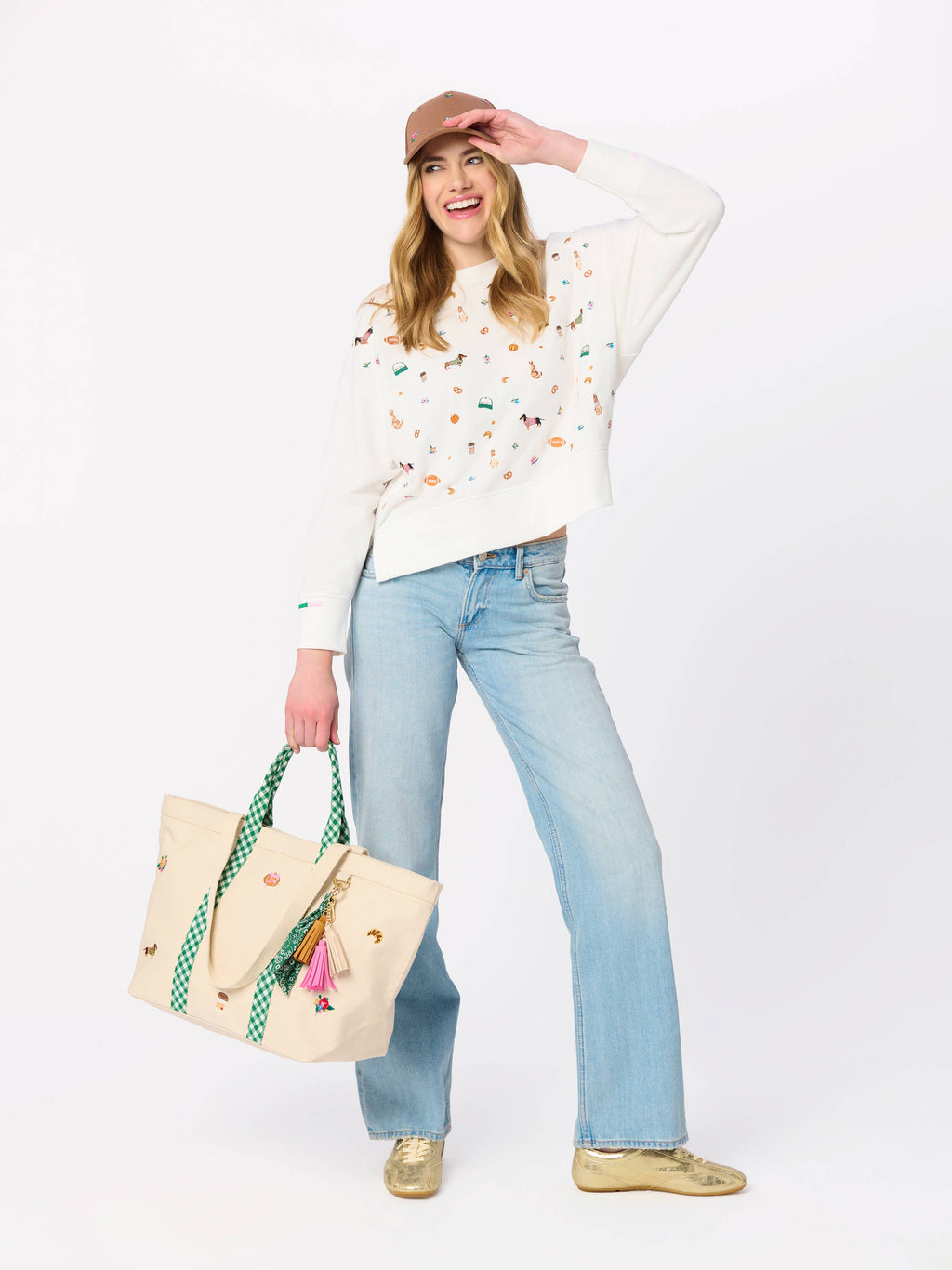 An off-white cropped crewneck sweatshirt featuring a colorful all-over print of equestrian-themed illustrations, including horses, bits, and riding gear, displayed on a clean white background.