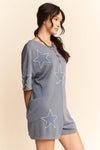 Woman wearing a gray dress with star patterns on a beige background