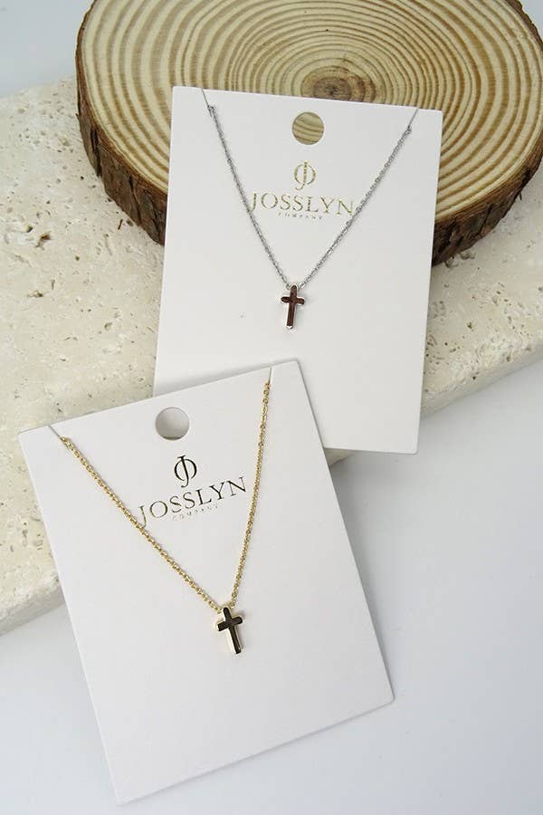Two gold necklaces with cross pendants on JOSSLYN branded cards, displayed against a neutral background.
