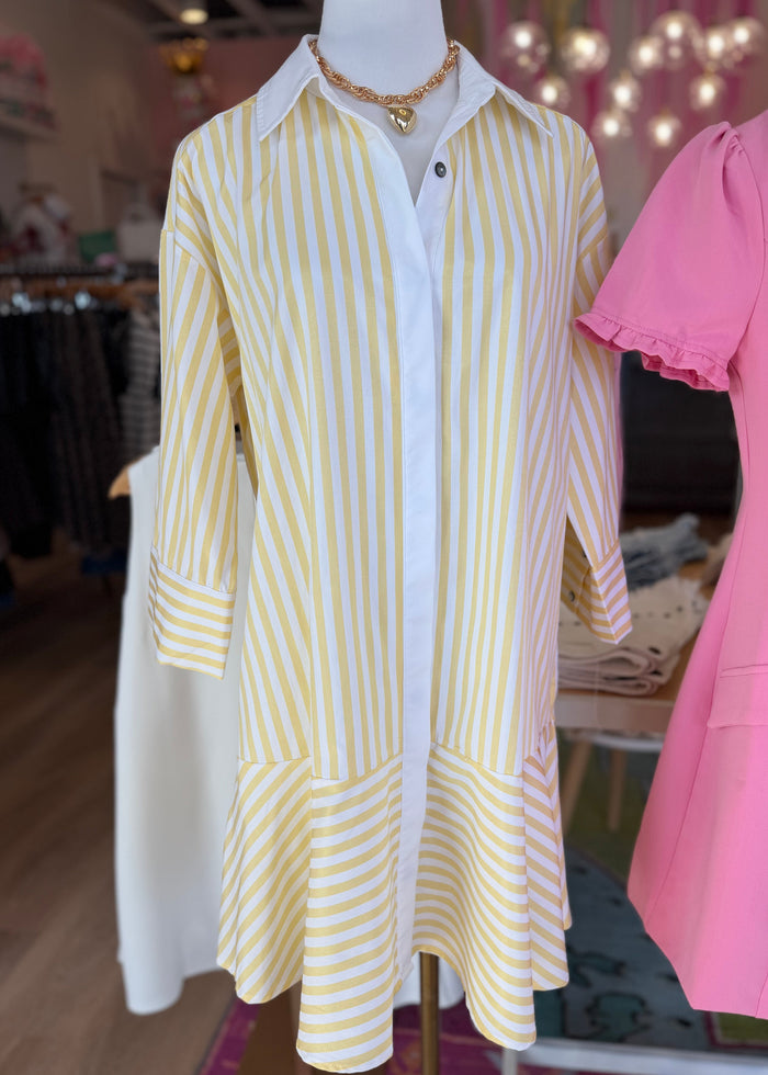 Mannequin wearing a yellow and white striped dress in a store setting with pink jacket.