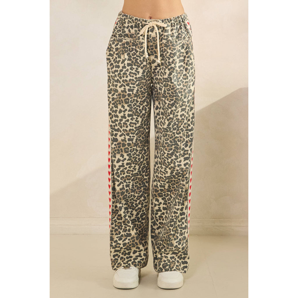 Leopard print pants with red heart pattern on a neutral background