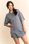 Woman wearing a gray dress with star patterns on a beige background