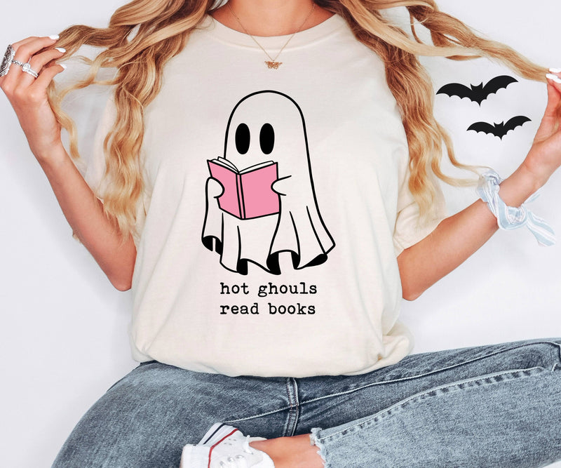 Person wearing a t-shirt with a ghost holding a book graphic and text 'hot ghouls read books'.