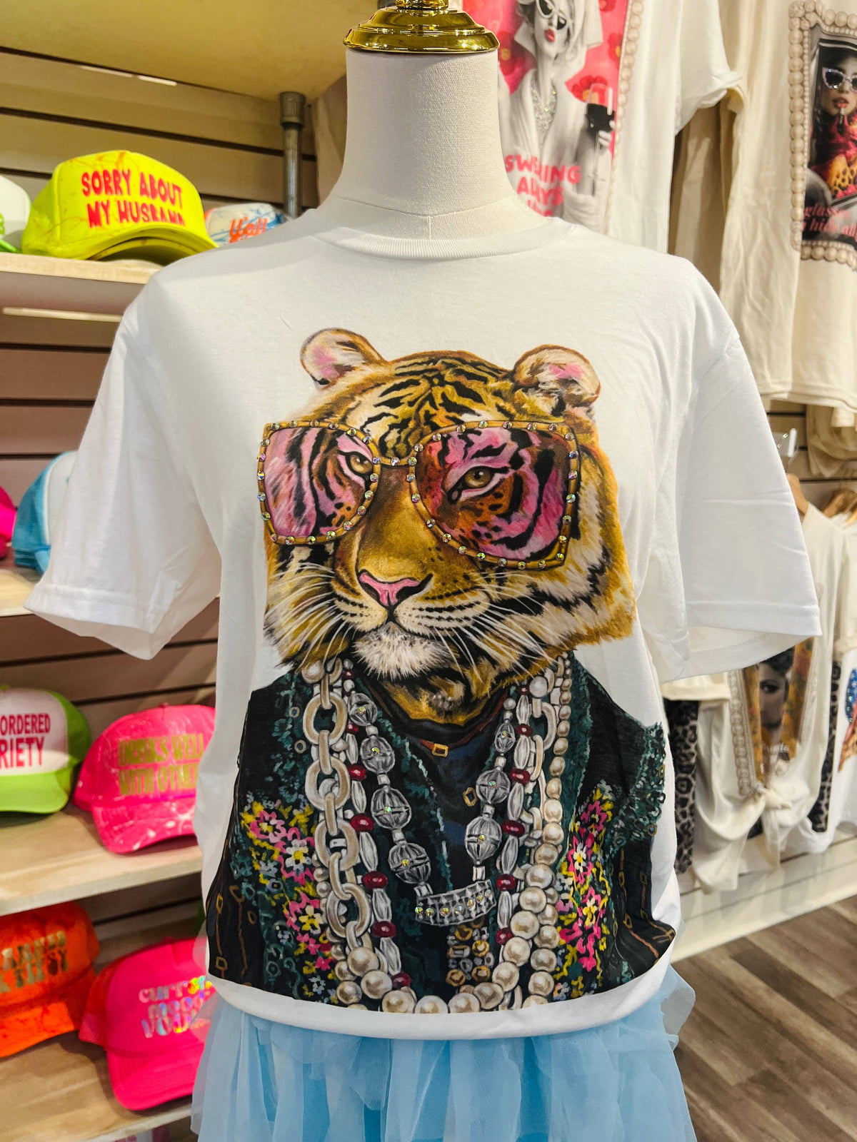 T-shirt with a tiger design wearing sunglasses and jewelry on a mannequin in a store setting.