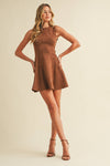 Woman wearing a brown dress against a beige background