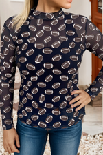 black long-sleeve top with football pattern worn by a person, standing against a neutral background.