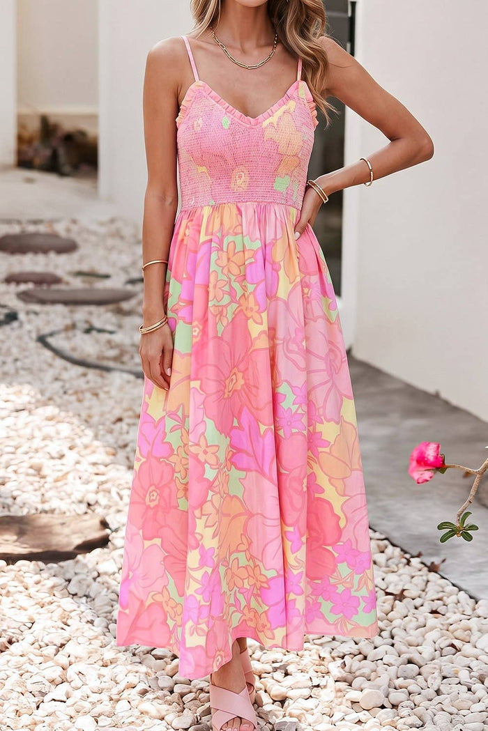 Woman wearing a colorful floral dress standing on pebbles with a blurred background