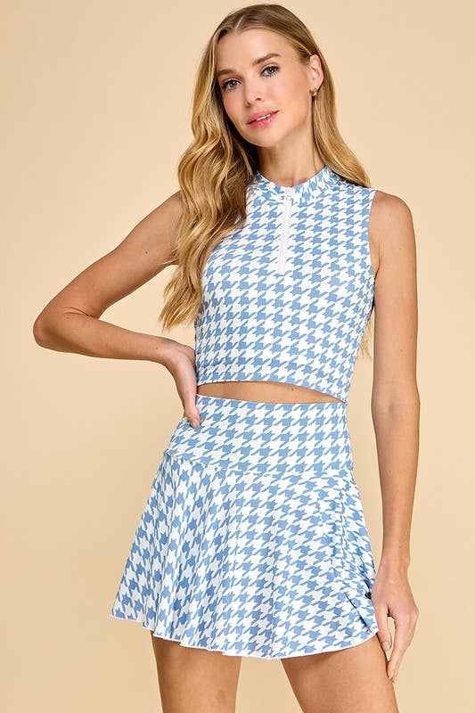 Woman wearing a blue and white houndstooth patterned two-piece outfit on a beige background
