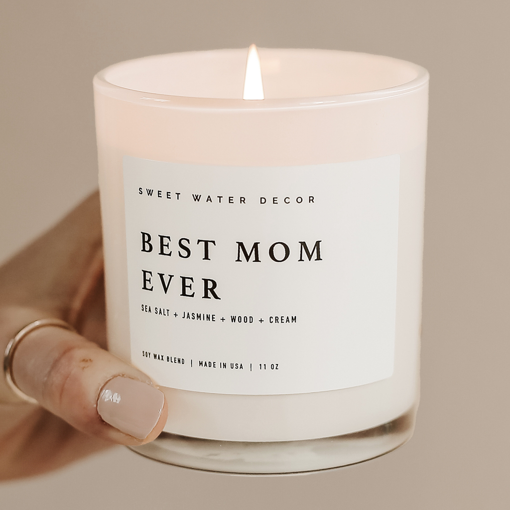 Candle with 'Best Mom Ever' label on a woven surface