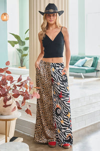 Woman wearing a black top and patterned pants in a modern living room.