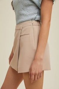 Beige skirt worn by a person on a beige background