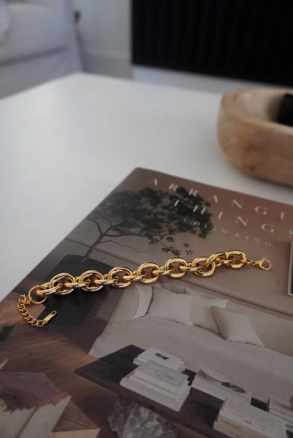 Gold chain bracelet on a magazine with a blurred background